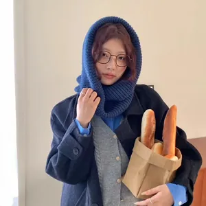 Stylish warm blue knitted hooded scarf for winter protection shown on a female model