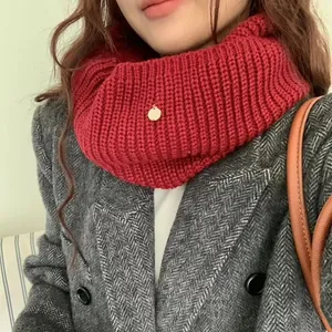 Thick red knitted neck warmer with metal tag shown on a model for winter warmth