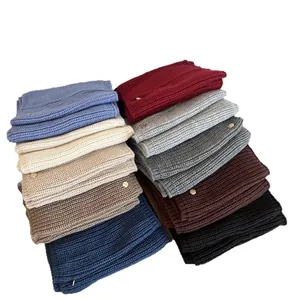 Assorted thick knitted winter neck gaiters in various colors featuring small metal tags