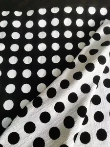 Primo piano di tessuto jacquard in ciniglia a pois bianchi e neri, trama morbida
