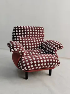 Dettaglio di una poltrona moderna rivestita in ciniglia a pois bordeaux e bianchi