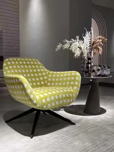 Primo piano della trama del tessuto in ciniglia a pois verdi su una poltrona moderna.