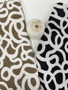 Gros plan de tissu jacquard chenille aux motifs ondulés abstraits or et noir de qualité.