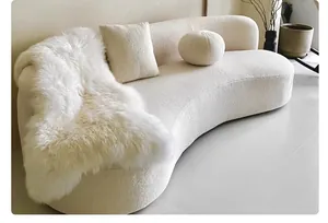 Close-up view of premium heavyweight cream bouclé fabric textured upholstery on a curved sofa