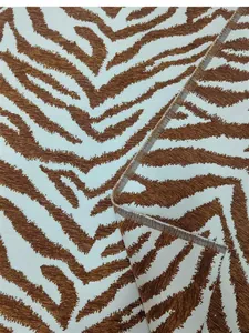 Primo piano dettagliato del tessuto ciniglia jacquard con motivo zebrato marrone decorativo.