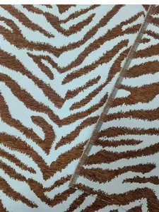 Dettaglio in primo piano di tessuto ciniglia jacquard con motivo zebrato marrone e bianco.