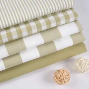 Stack of sage green and white checkered and striped faux linen fabrics for DIY upholstery
