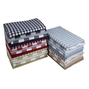 Neatly stacked checkered and striped linen-style fabric pieces for DIY upholstery projects
