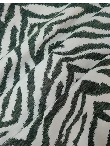 Vista dettagliata del tessuto ciniglia jacquard zebra verde e bianco per cuscini e divani.