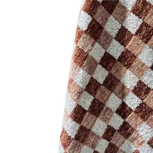 Close-up of thick checkered chenille jacquard fabric in brown and beige tones.