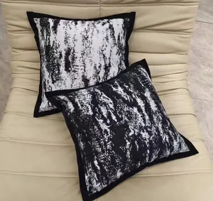 Modern black and white ink wash style velvet throw pillow covers on a beige sofa