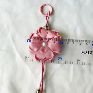 Detailed view of pink ribbon clover keychain showing size of approximately 5.5cm