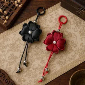 Detailed view of handmade satin clover flower keychains with pearl centers and beads