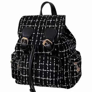 Detail shot of black and white tweed backpack with leather trim, stylish casual daypack.