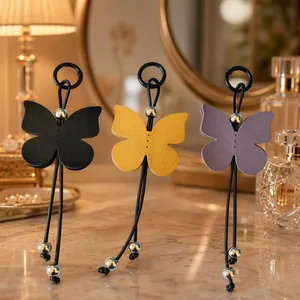 Detail view of three colorful butterfly leather charms on a luxury vanity tabletop