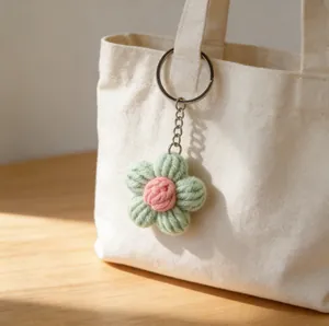 Gros plan d'un porte-clés fleur de bouffée au crochet suspendu à un sac en toile blanc