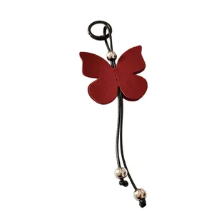Elegant red PU leather butterfly keychain featuring silver beads for backpack decoration