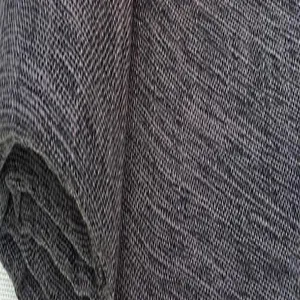 Vue rapprochée montrant la texture flammée naturelle et le tissage d'un tissu en lin gris