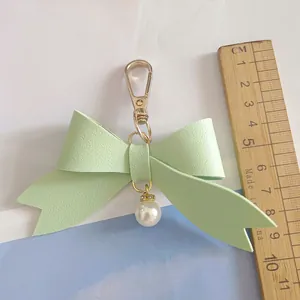 Cute mint green PU leather bow keychain with white pearl charm and size reference ruler