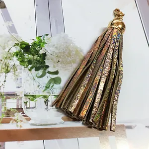 Macro detail showing the iridescent texture of a gold-capped leather tassel charm
