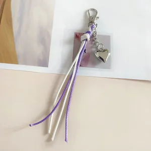 Portachiavi fatto a mano con nappa in filo cerato intrecciato viola e bianco con cuore