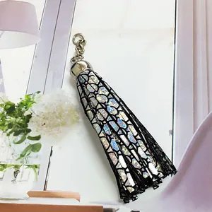 Close-up of holographic leather tassel pendant with lattice pattern and silver metal cap
