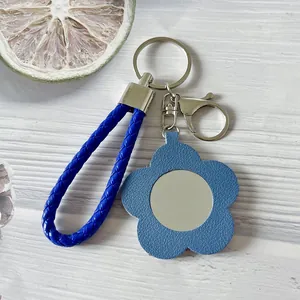 Elegante portachiavi in pelle blu a forma di fiore con mini specchio da trucco portatile