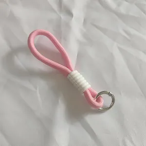 Primer plano de un cordón trenzado rosa con agarre de goma blanca y anillo de metal plateado