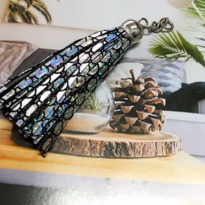 Close-up of holographic leather tassel pendant with silver metal ring for bags and keys
