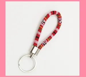 Detailed view of an ethnic style woven red fabric keychain with a sturdy silver metal ring