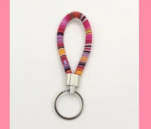 Close-up detail of ethnic style woven fabric lanyard keychain featuring colorful stripes.