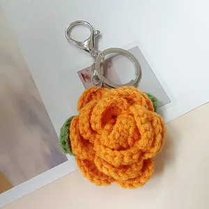Handmade orange crochet rose keychain with a silver metal clip, perfect for bag charm