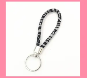 Macro detail of ethnic style woven fabric keychain featuring a black and white pattern