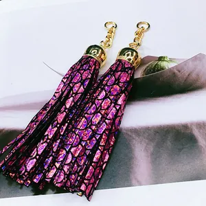 Close-up of holographic purple leather tassels with gold-toned metal caps and chains