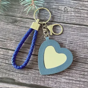Porte-clés miroir en cœur cuir bleu avec dragonne tressée pour maquillage.