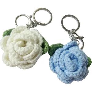 Hand-crocheted rose flower keychains made of soft wool yarn in white and light blue colors