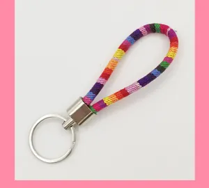 Detailed macro view of colorful ethnic style braided fabric rope keychain with metal ring