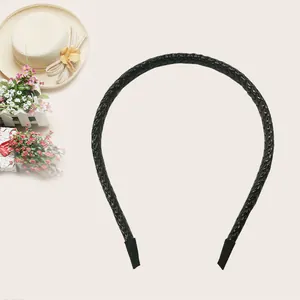 Close-up of a black braided PU leather headband with elegant texture and soft padding.
