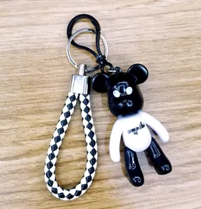 Macro view of a creative black and white bear keychain with a braided leather strap