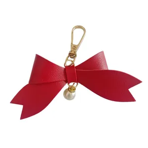 Red PU leather bow keychain with pearl charm and gold lobster clasp for bag accessory