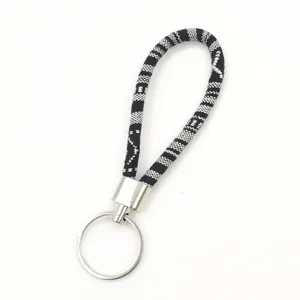 Handmade ethnic style woven fabric keychain with decorative black and white tribal pattern