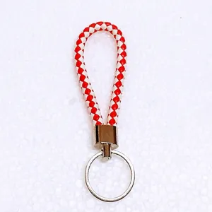Detailed macro view of a red and white braided leather rope keychain with a silver key ring.