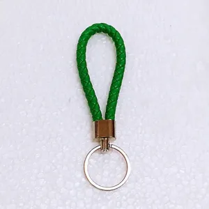 Detailed macro view of a vibrant green braided leather keychain with silver hardware