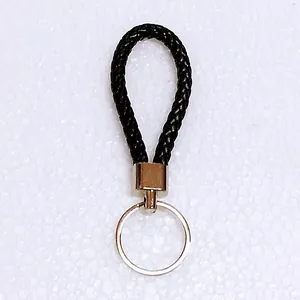 Close-up of a premium black braided leather keychain featuring a polished silver split ring