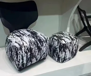 Detail of modern velvet fabric ottoman featuring abstract black and white ink wash pattern