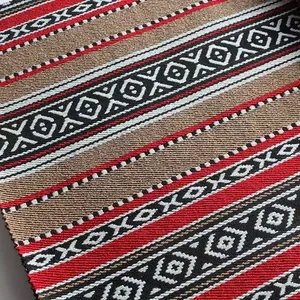 Primo piano di tessuto jacquard intrecciato in stile etnico con motivi geometrici rossi.