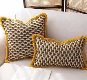 French vintage jacquard shell pattern throw pillows with yellow fringe on a cozy sofa