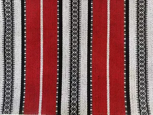 Primo piano macro di un tessuto jacquard in stile etnico con strisce rosse e nere