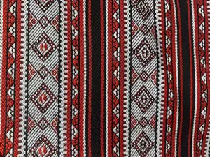 Primo piano macro dettagliato di tessuto jacquard etnico rosso e nero con motivi geometrici