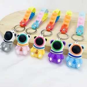 Detailed view of colorful astronaut bear keychains with pop-it stress relief straps